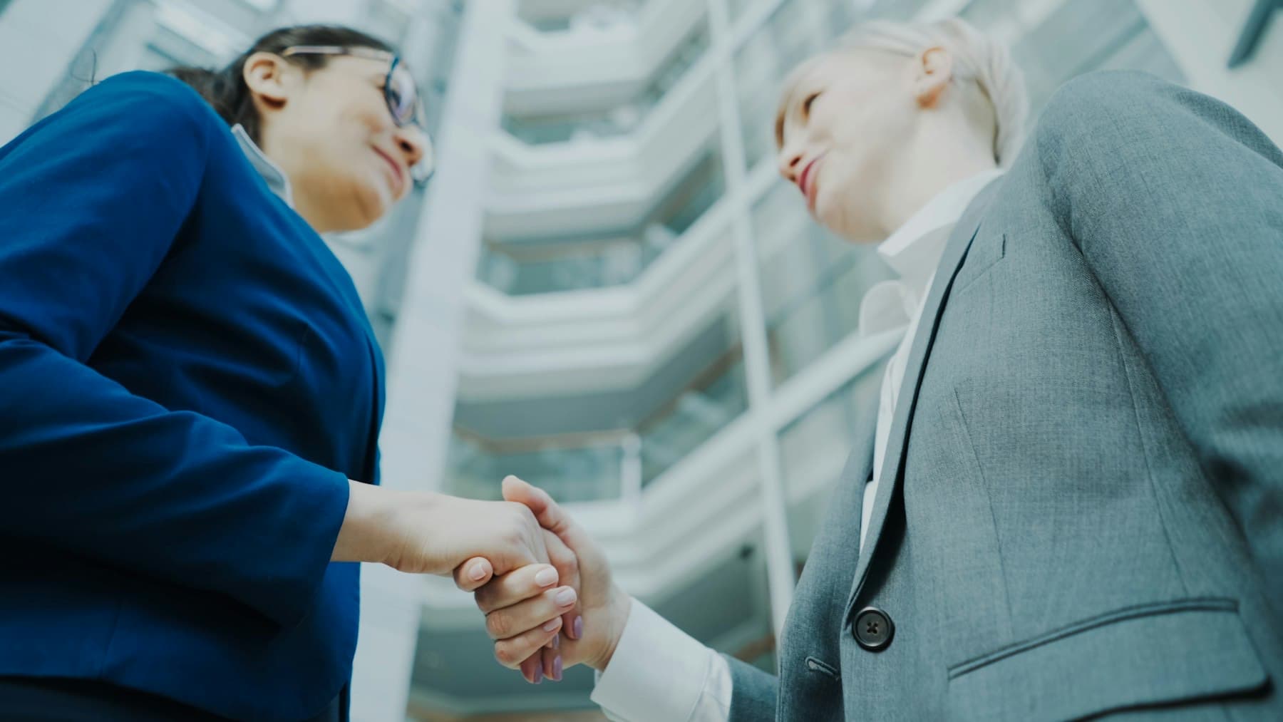 Two professionals shaking hands in a modern office