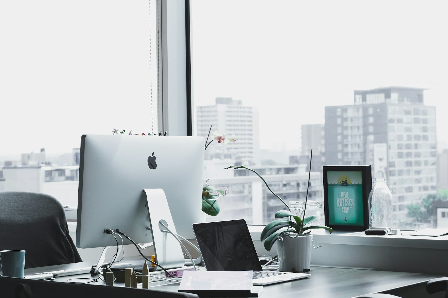 A bright designer's desk with a desktop computer overlooking the city