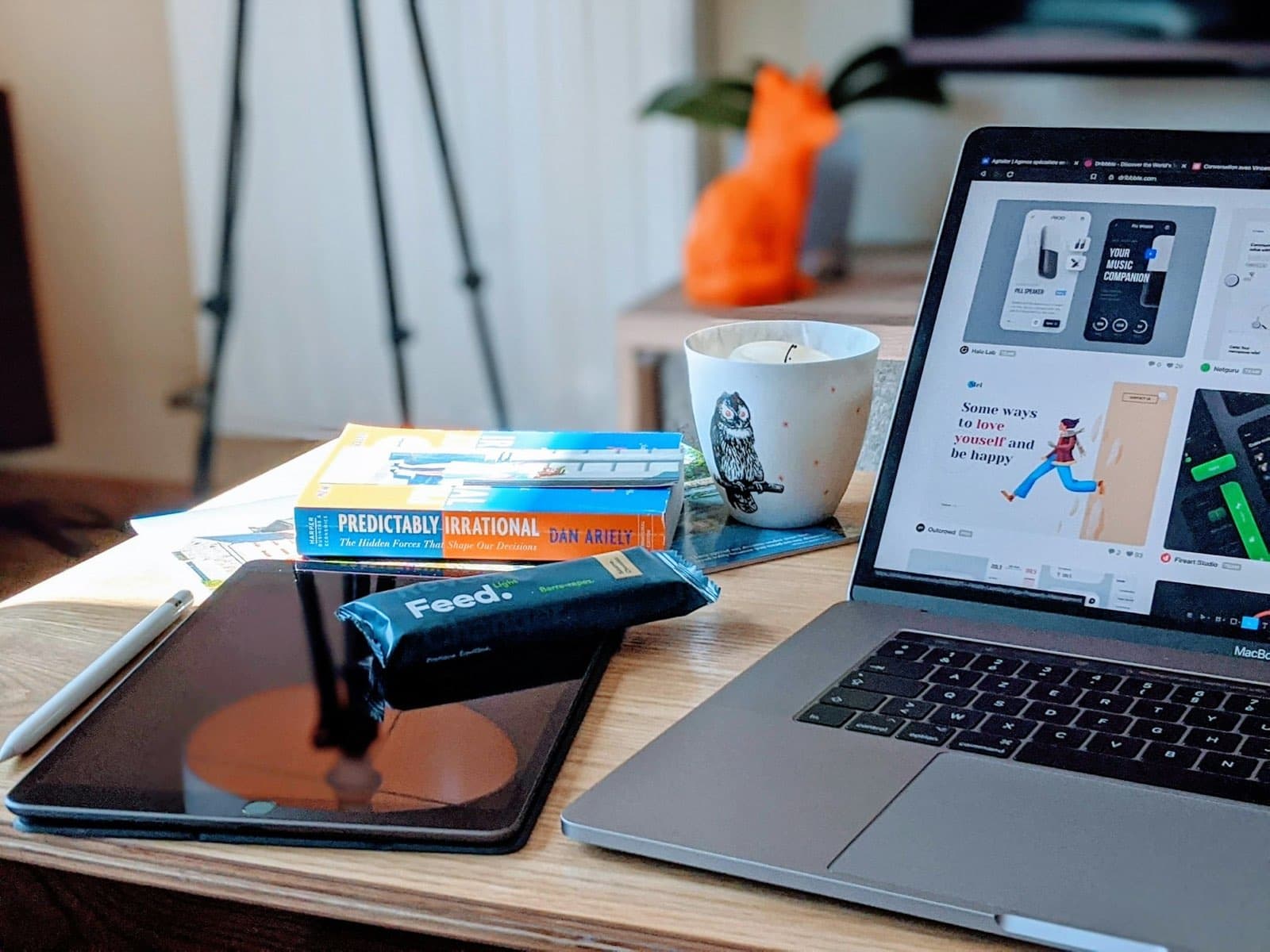 Designer's laptop showing an interface design beside reference books